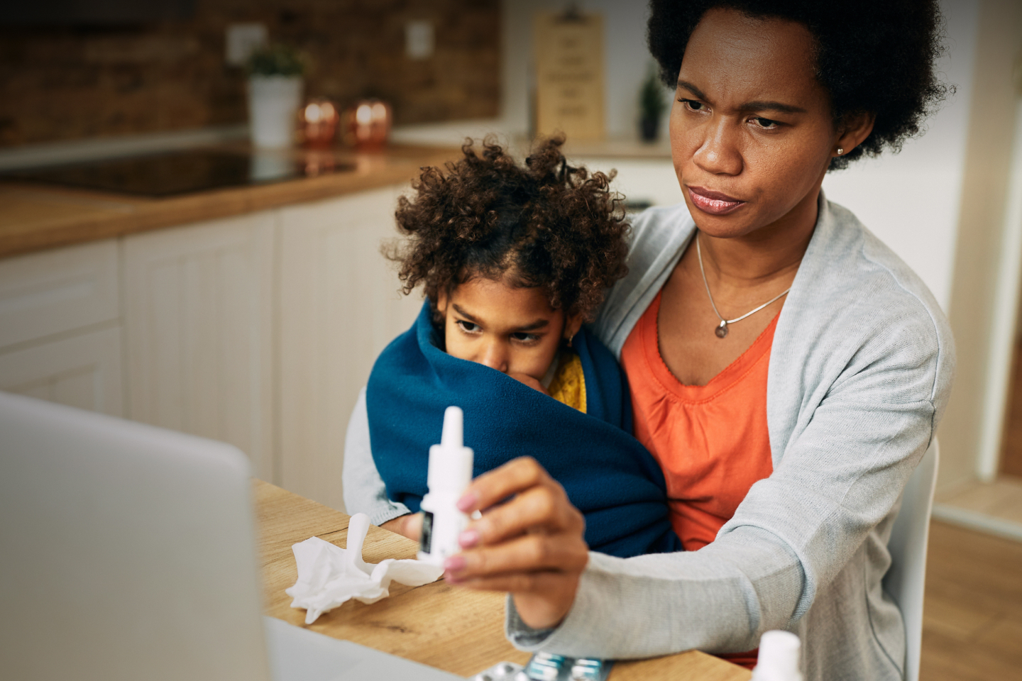 In-Office & In-Room Medical Services for Mom and son showing medication to a doctor through telemedicine on a computer.